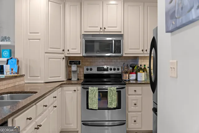 a kitchen with stainless steel appliances granite countertop a stove a microwave and a refrigerator