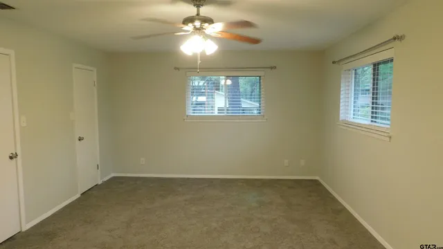 en empty room with windows and fan