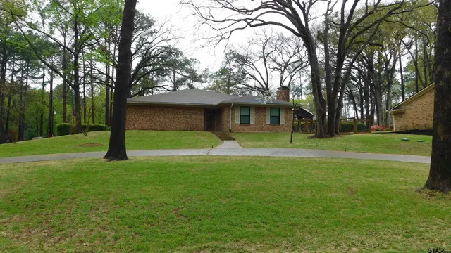 a front view of a house with yard and green space