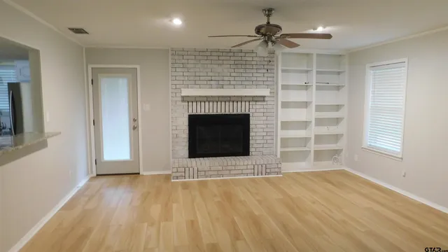 a view of an empty room with a fireplace and a window