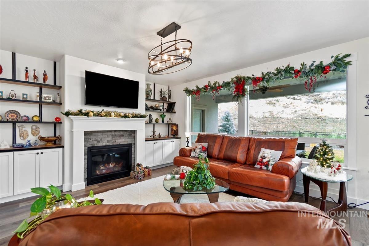 20530 North Shepherds Pie Way Boise, ID 83714 - Photo 3 of 47 Living area featuring wood finished floors, a fireplace, and a chandelier