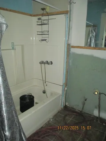 a bathroom with a tub a sink and a window