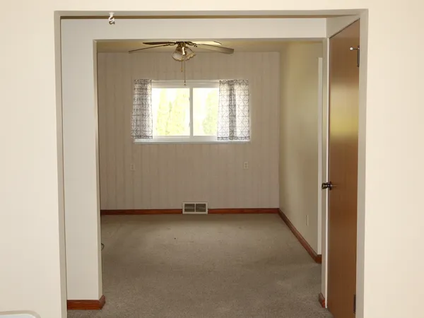 a view of a small space with wooden floor and a window