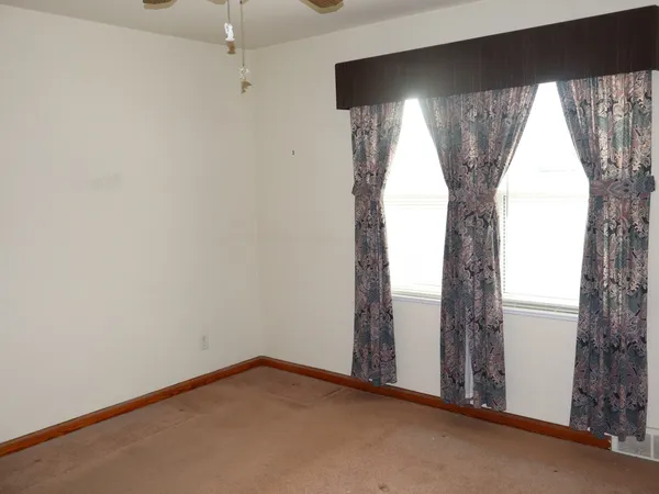 an empty room with windows and closet