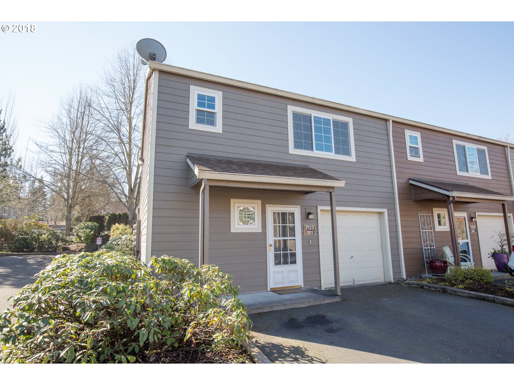 7123 Southwest Sagert Street, Unit 101 Tualatin, OR 97062 - Photo 1 of 24 a front view of a house with a yard