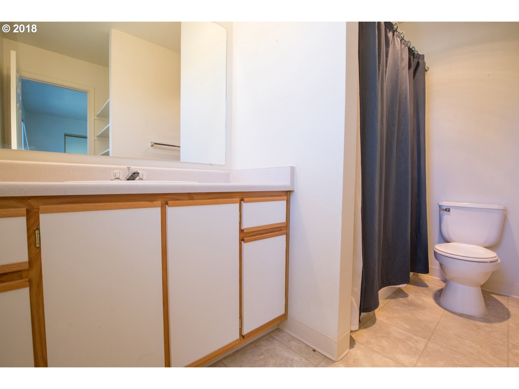 7123 Southwest Sagert Street, Unit 101 Tualatin, OR 97062 - Photo 12 of 24 a bathroom with a toilet sink and a mirror