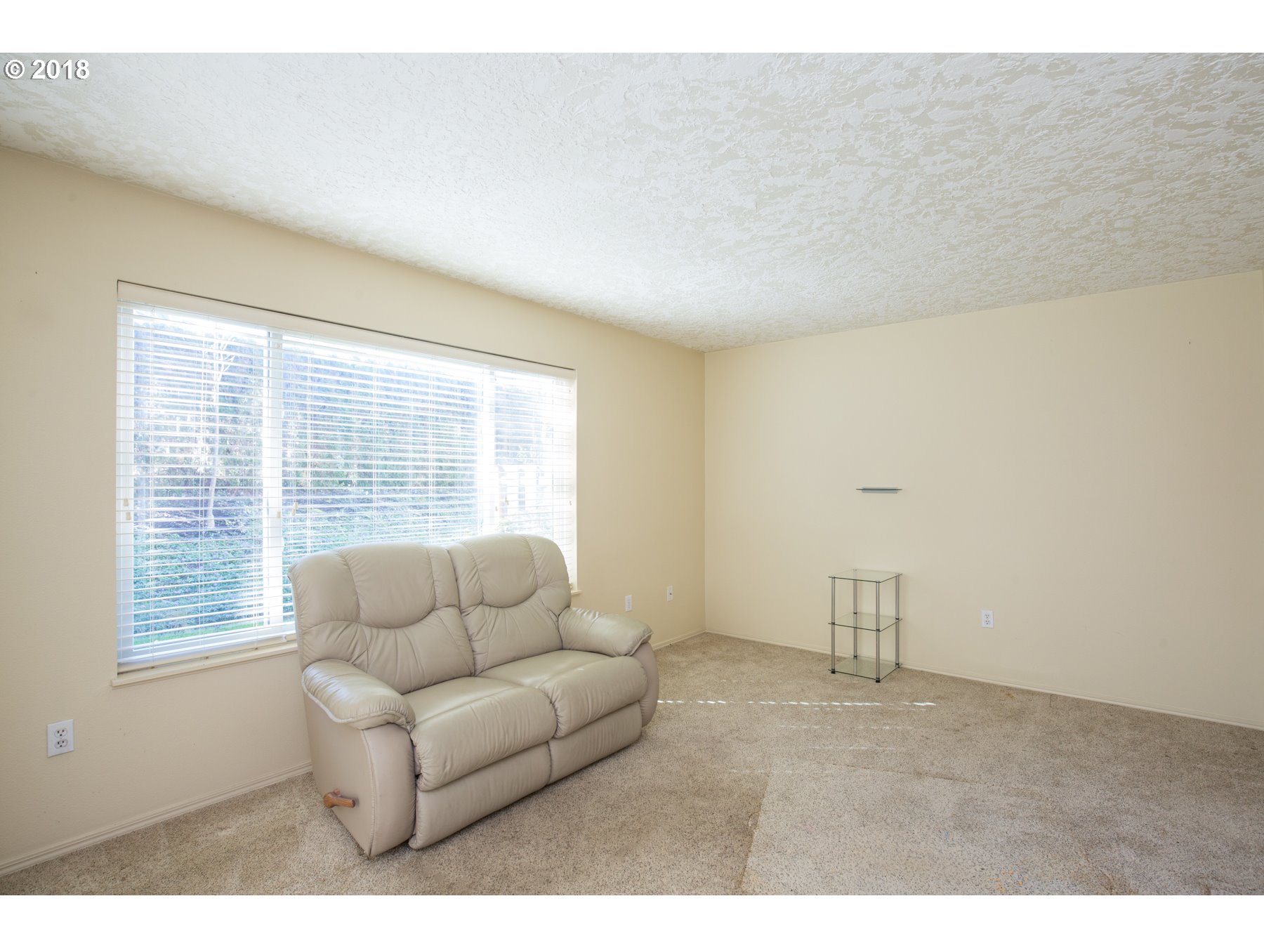 7123 Southwest Sagert Street, Unit 101 Tualatin, OR 97062 - Photo 5 of 24 a living room with furniture and a floor to ceiling window