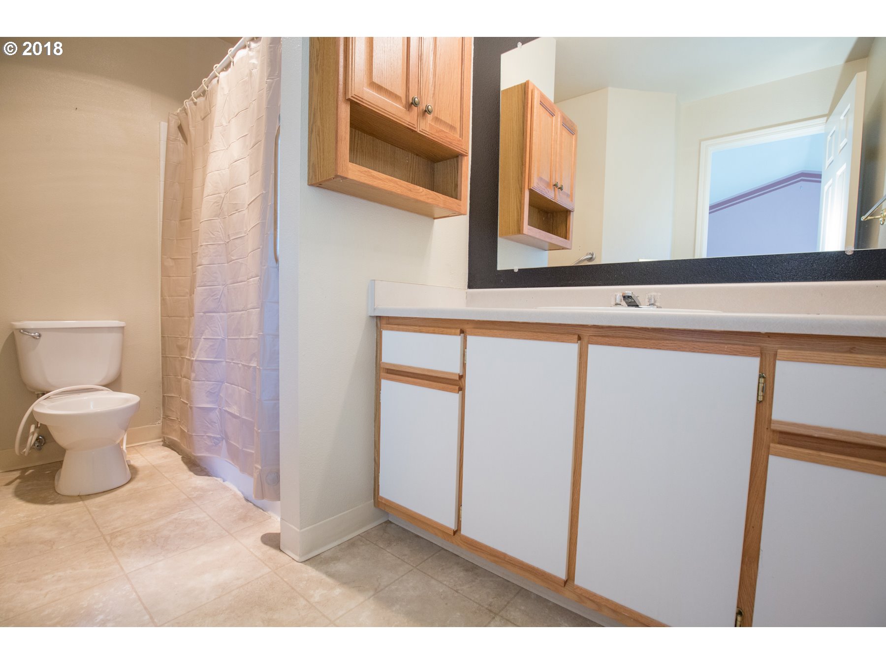 7123 Southwest Sagert Street, Unit 101 Tualatin, OR 97062 - Photo 9 of 24 a bathroom with a toilet sink and mirror