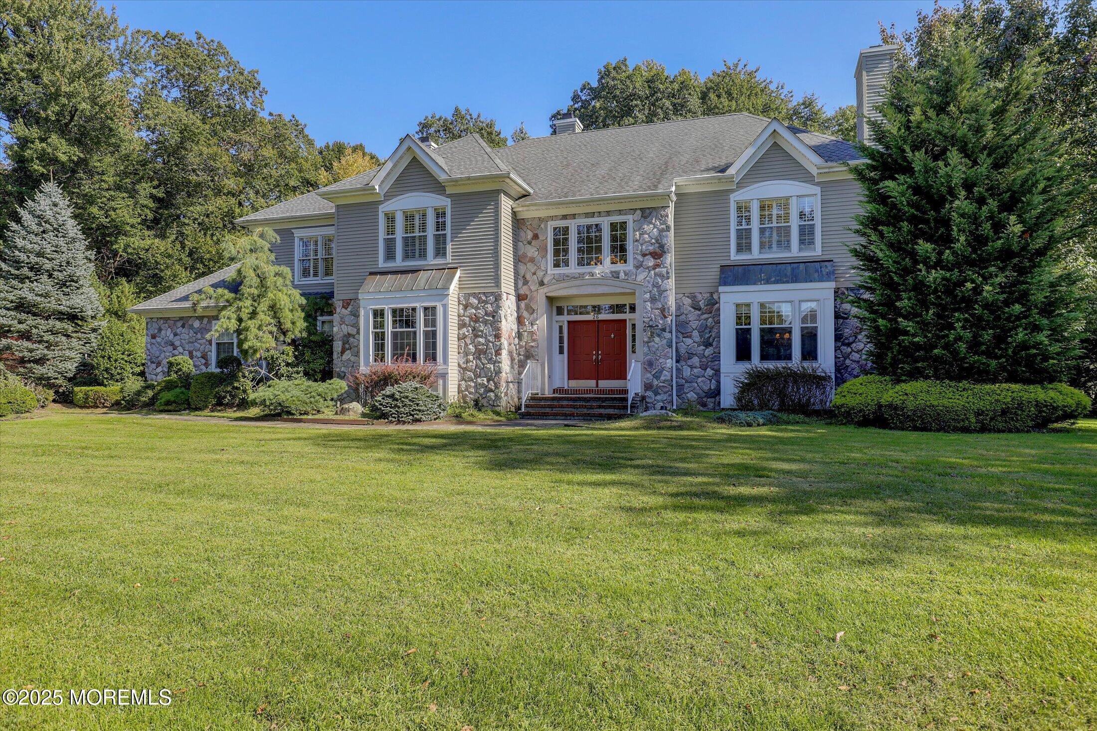 a view of a big house with a big yard and large trees