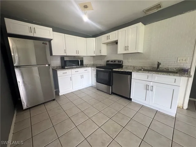 a kitchen with stainless steel appliances granite countertop a sink stove and cabinets