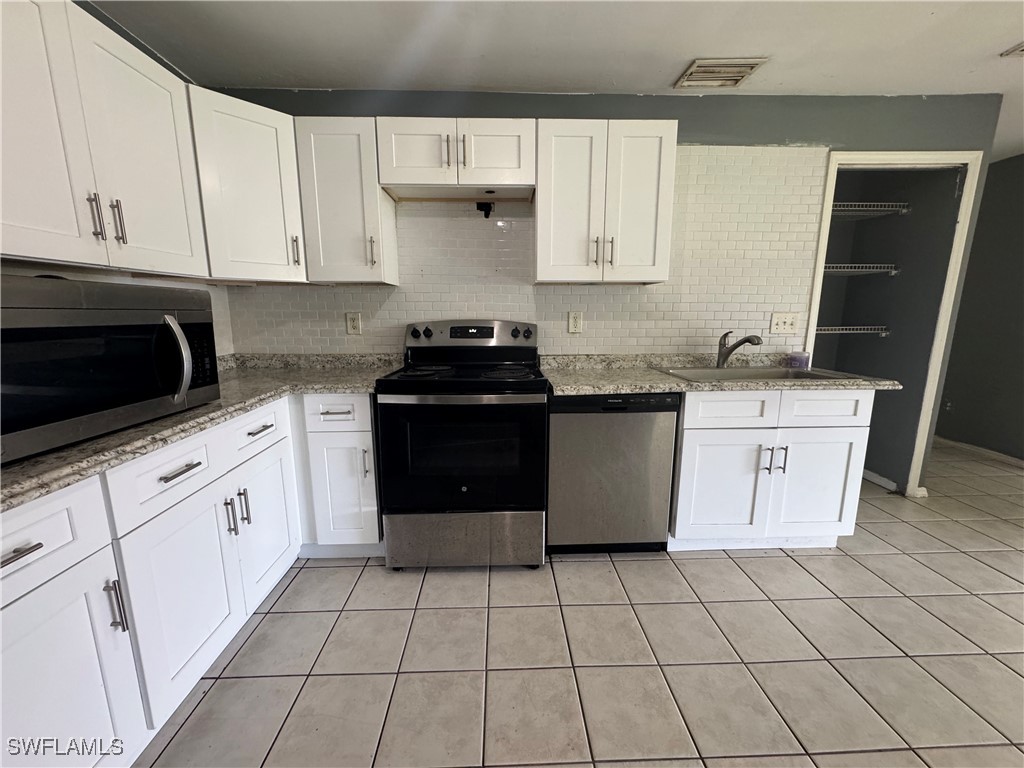 4541 21st Street Southwest Lehigh Acres, FL 33973 - Photo 8 of 15 a kitchen with stainless steel appliances granite countertop a sink stove and cabinets