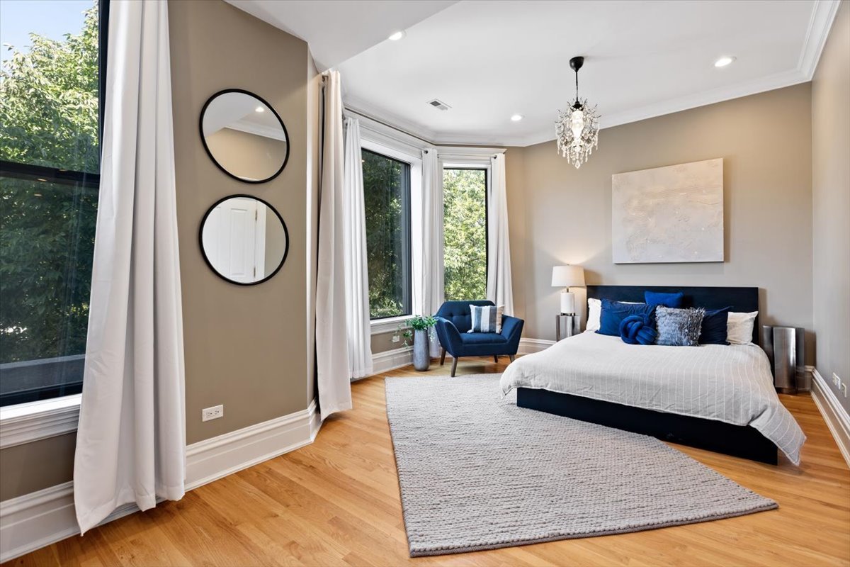 2845 West Division Street Chicago, IL 60622 - Photo 19 of 49 a bedroom with a large bed and a chandelier