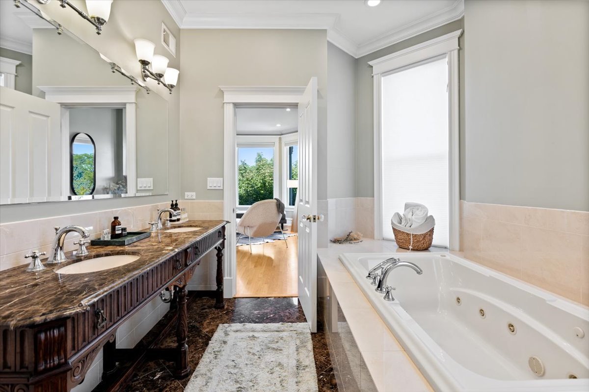 2845 West Division Street Chicago, IL 60622 - Photo 26 of 49 a spacious bathroom with a granite countertop sink a bathtub a mirror and vanity