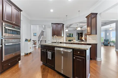 a kitchen with stainless steel appliances granite countertop a stove a sink and a refrigerator