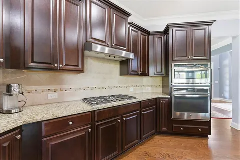 a kitchen with stainless steel appliances granite countertop a sink and stove