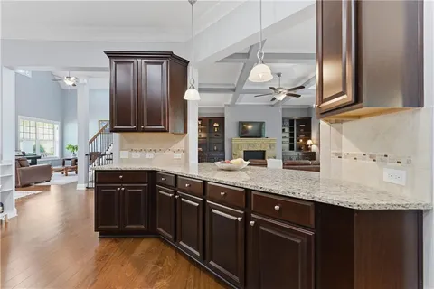 a kitchen with stainless steel appliances granite countertop wooden cabinets a refrigerator a stove a sink and dishwasher