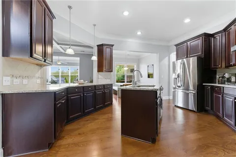 a bathroom with a granite countertop sink toilet and mirror