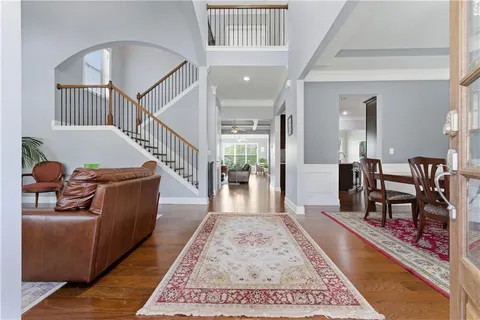 a living room with furniture rug and a dining table