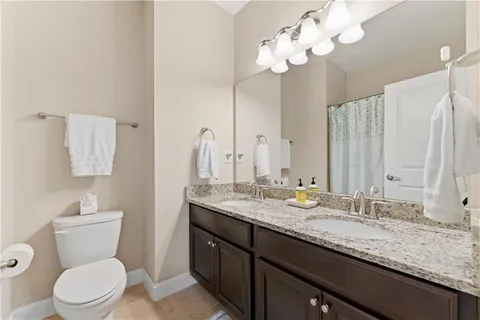 a bathroom with a granite countertop shower a toilet and a shower