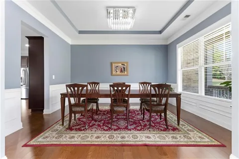 a view of a dining room with furniture a rug and wooden floor