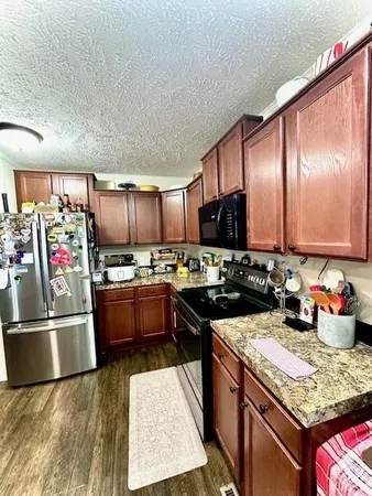 a kitchen with stainless steel appliances granite countertop a stove refrigerator and sink