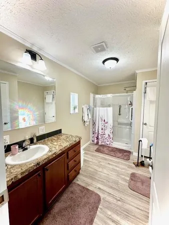 a spacious bathroom with a granite countertop sink a mirror and a
