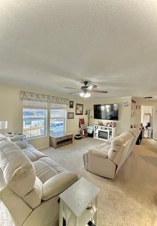 a living room with furniture flat screen tv and a large window