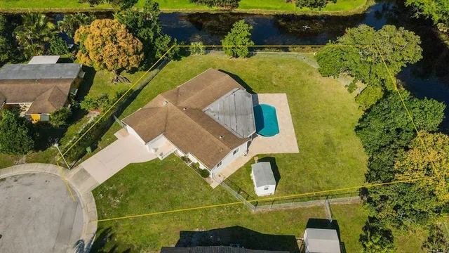 an aerial view of a house with a yard basket ball court and outdoor seating