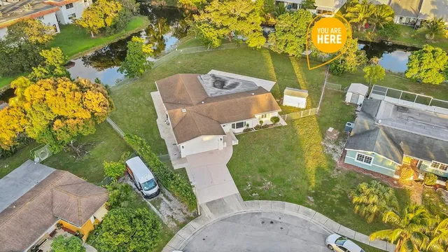 an aerial view of a house with a garden and trees