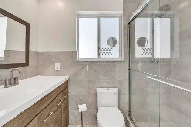 a bathroom with a sink a toilet and shower