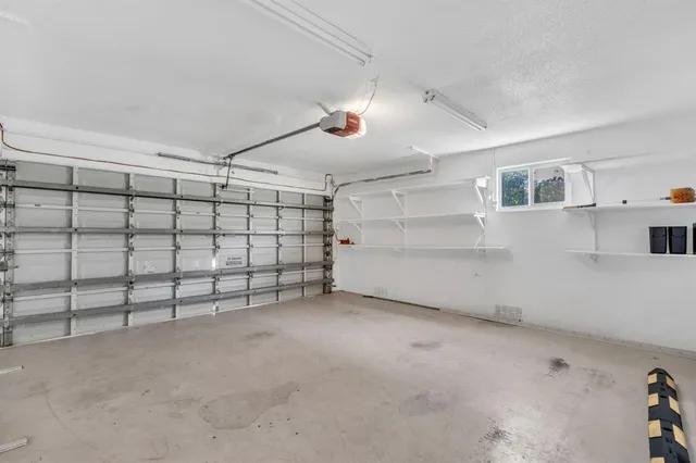 a white house with a big yard and potted plants