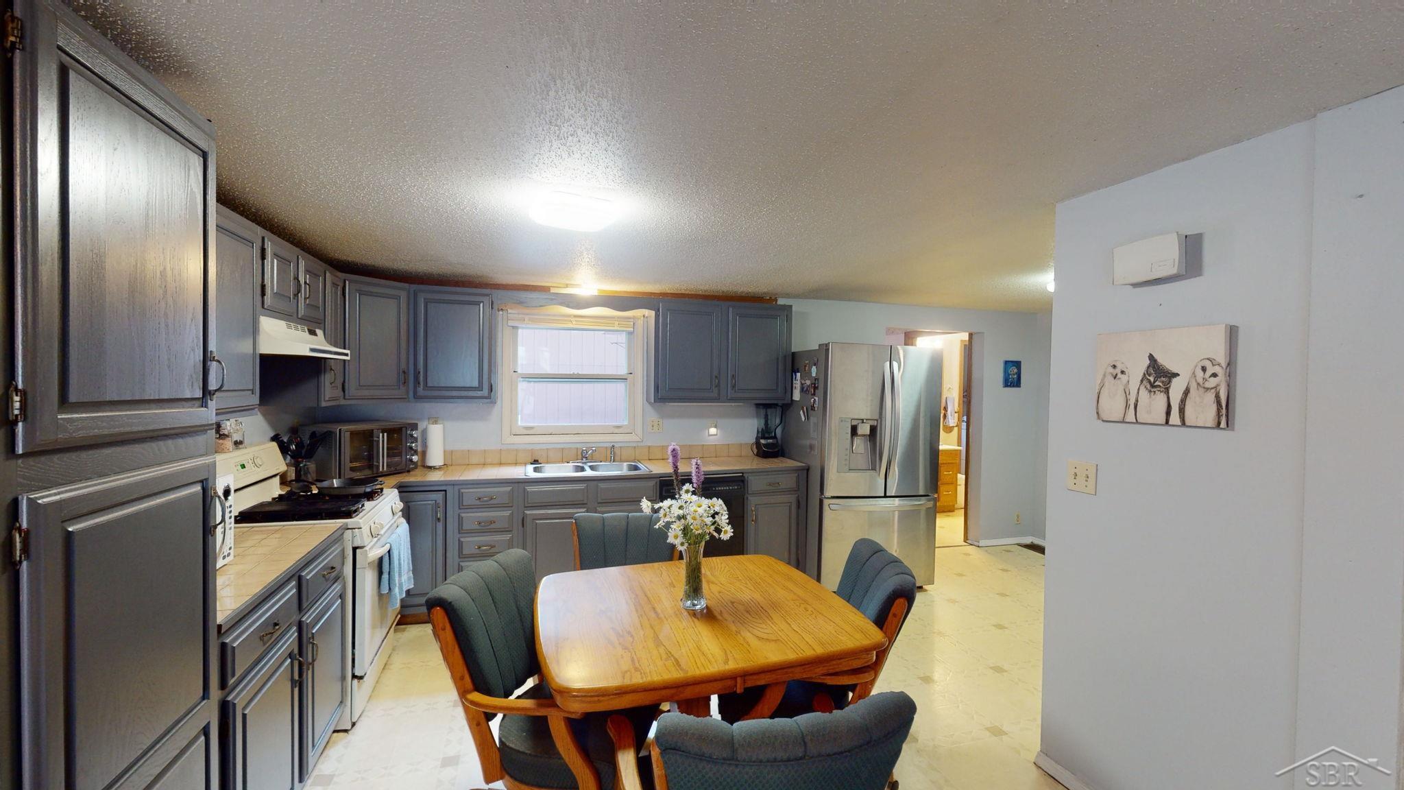 670 Lone Pine Road Harrison, MI 48625 - Photo 33 of 34 This open floorplan has the kitchen at the heart of the home- open to the large living room, and primary bedroom, bathroom and entryway. Two additional bedrooms and a bathroom are around the corner f