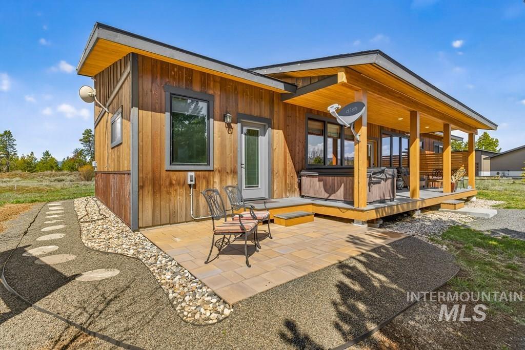 13800 Raptor Loop McCall, ID 83638 - Photo 26 of 34 Wood-sided exterior featuring an expansive covered porch with wood columns and ceiling, a built-in spa, and a paver patio