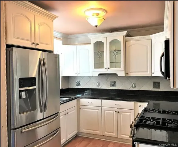 a kitchen with granite countertop a refrigerator sink and stove