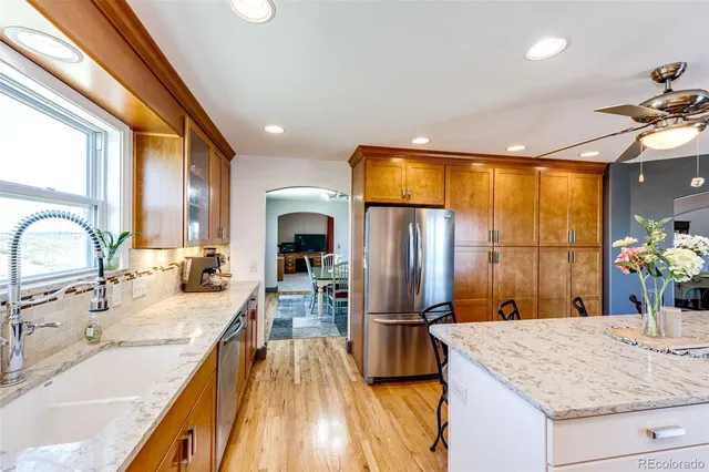 a spacious bedroom with a bed a chandelier and windows
