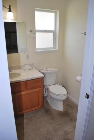 a bathroom with a toilet sink and mirror
