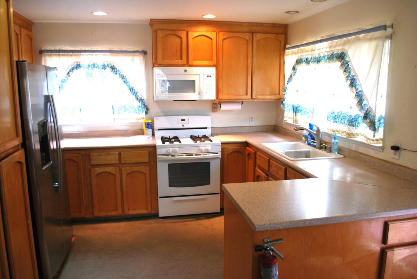 9194 Coker Road Salinas, CA 93907 - Photo 6 of 27 a kitchen with a stove a sink and a refrigerator