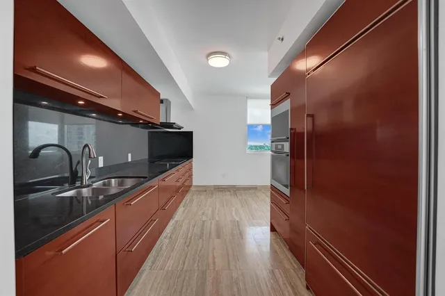 a view of a room with wooden floor and electronic appliances