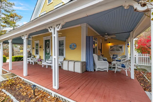 a view of a patio with table and chairs with wooden floor and fence