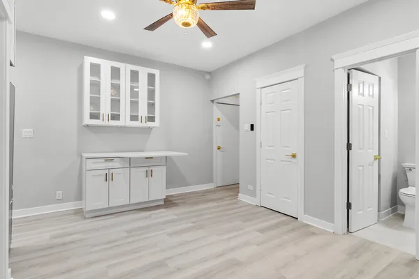 an empty room with windows and cabinet