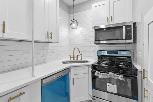 a kitchen with cabinets stainless steel appliances and a sink
