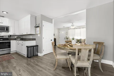 a dining room with furniture a floor to ceiling window and wooden floor