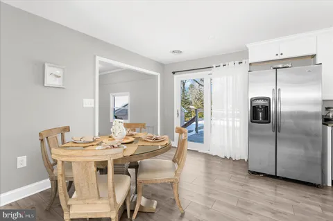 a kitchen with granite countertop white cabinets appliances and a window