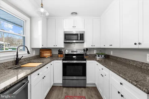 a kitchen with stainless steel appliances granite countertop a refrigerator and a stove