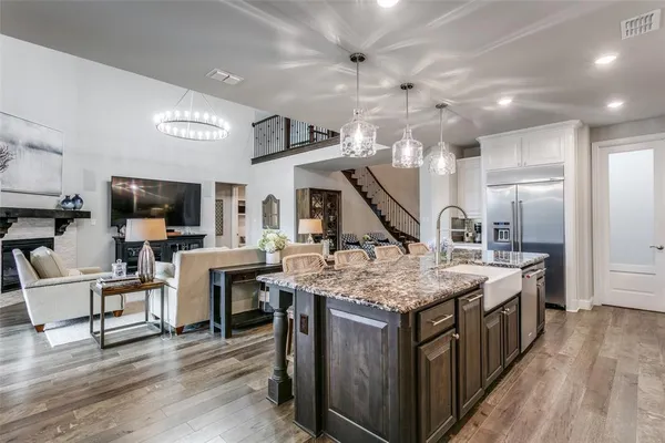 a kitchen that has a lot of cabinets a sink and wooden floor