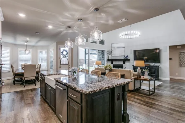a kitchen with granite countertop kitchen island stainless steel appliances sink dining table and chairs