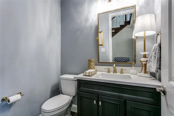 a bathroom with a sink vanity mirror and toilet