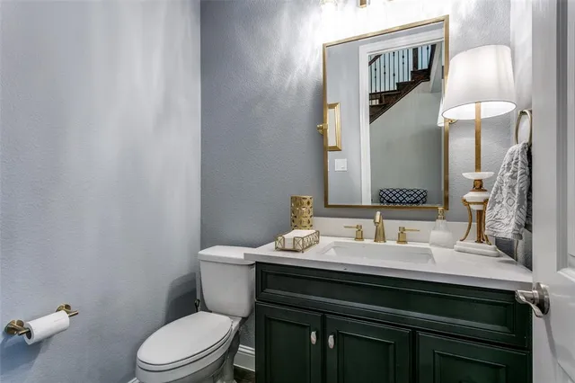 a bathroom with a sink vanity mirror and toilet