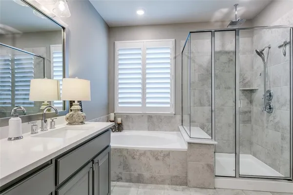 a bathroom with a granite countertop sink a mirror and shower