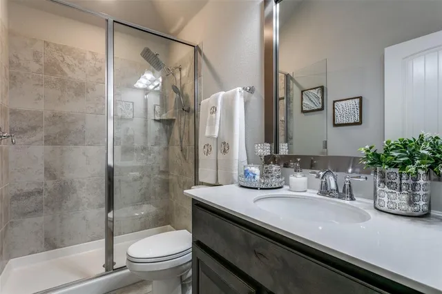 a bathroom with a granite countertop sink a toilet and shower